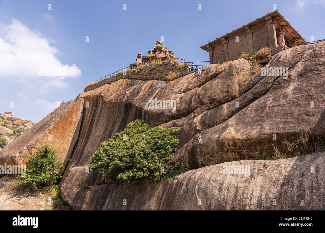 Chitradurga, Karnataka, India - 10 novembre 2013: Fort o Elusuttina Kote. Hidambeswara Temple peeks top sopra enormi massi neri marroni sotto bl Foto Stock