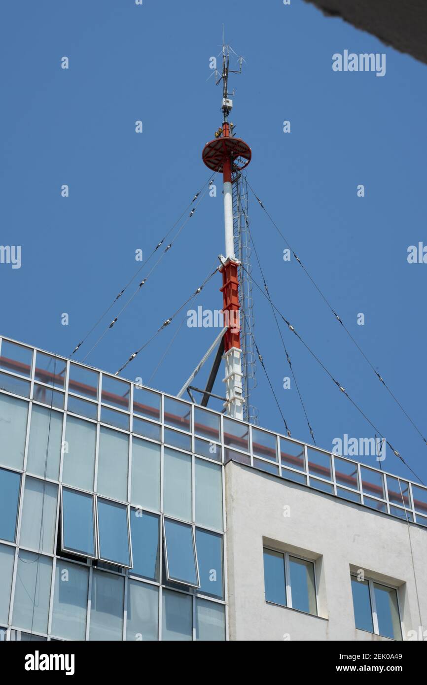 Stazione meteo palo sul tetto del moderno edificio di uffici a Bucarest, Romania Foto Stock