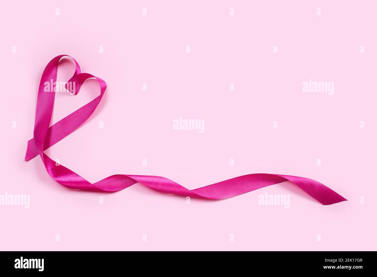 Il nastro è un segno cardiaco su sfondo rosa. Concetto di giorno di San Valentino. Buon giorno di San Valentino. Foto Stock