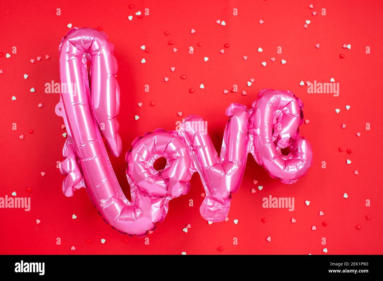 Palloncino in aria rosa a forma della parola Amore su sfondo festivo. San Valentino. Concetto di amore. Festa, festa. Foto Stock