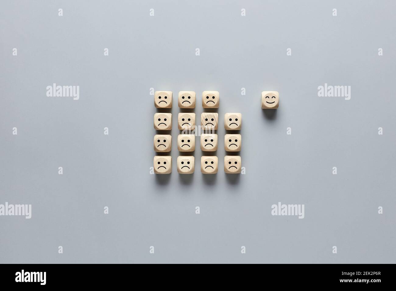 Il cubo di legno con l'icona del volto felice si distingue dalle icone del volto triste. Concetto di soddisfazione del cliente o del cliente. Foto Stock