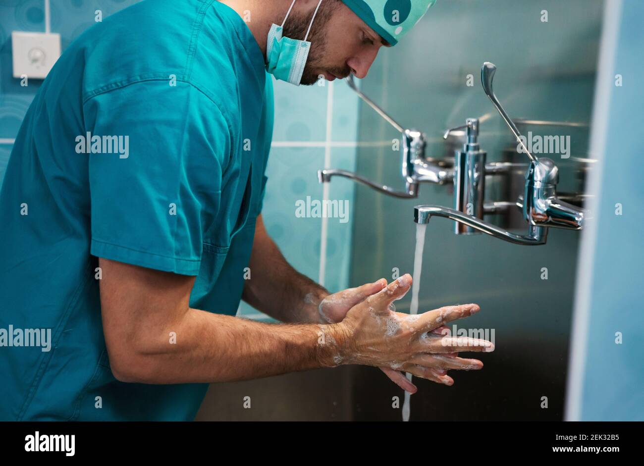 Uomo chirurgo lavarsi le mani in ospedale. Concetto di sanità e medicina Foto Stock
