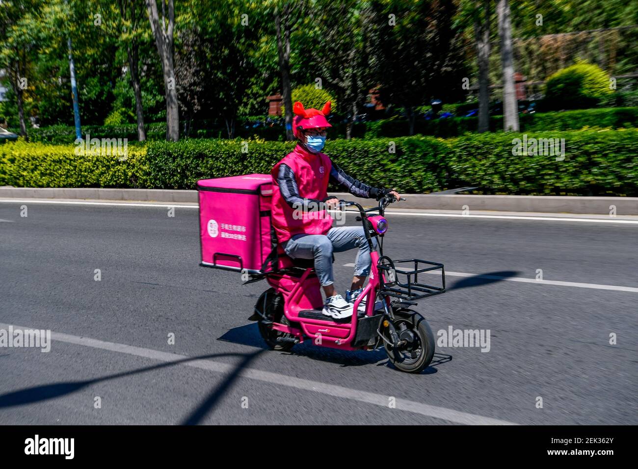 Un pilota indossa il casco mentre guida il suo scooter, Pechino, Cina, 19  maggio 2020. A partire dal 1° giugno, la nuova politica del traffico cinese  richiede caschi per tutti i motociclisti