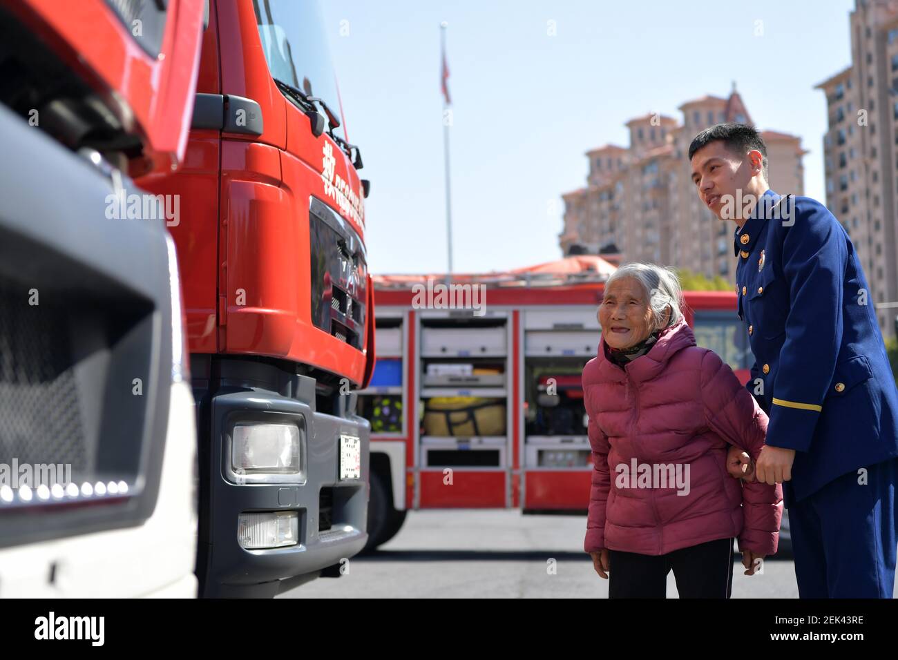 (210223) -- NANCHANG, 23 febbraio 2021 (Xinhua) -- Zhang Jiagang prende 'nonna' Tang Caiying per visitare il suo luogo di lavoro nella contea di Fenyi, città di Xinyu della provincia di Jiangxi della Cina orientale, 20 febbraio 2021. Zhang Jiagang, 24 anni, ora vigile del fuoco nella Contea di Fenyi della città di Xinyu, è stato trovato abbandonato e adottato 24 anni fa da Tang Caiying, che ora ha 85 anni. Tang Caiying e suo marito hanno allevato la propria figlia e sei fondazioni da soli per stipendi, vendendo verdura e rifiuti. Nel 2001, i vigili del fuoco nella contea di Fenyi iniziarono ad aiutare Tang Caiying e la sua famiglia dopo aver conosciuto loro Foto Stock