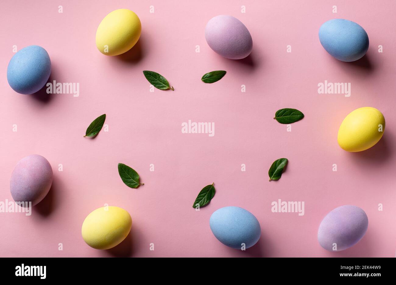 confine creativo di pasqua con uova colorate e foglie verdi Foto Stock