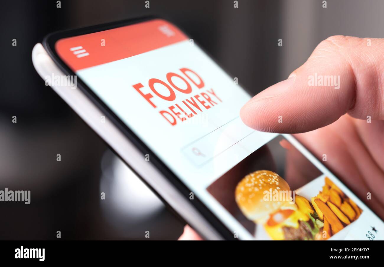 Servizio di consegna cibo al ristorante al telefono. Menu "Take away" nell'app mobile digitale. Uomo che ordina pizza da asporto o hamburger online. Pranzo veloce consegnato. Foto Stock
