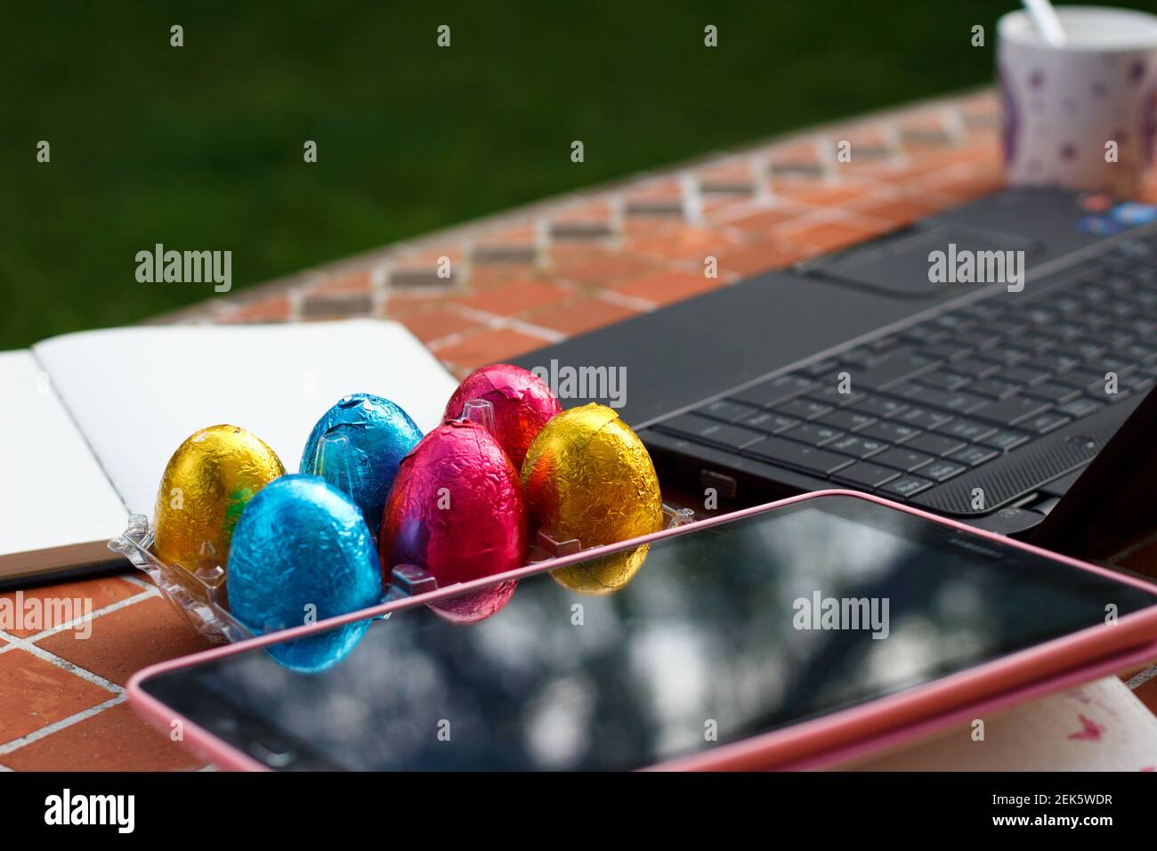 uova colorate per pasqua insieme a computer e tablet, la preparazione di giochi interattivi Foto Stock