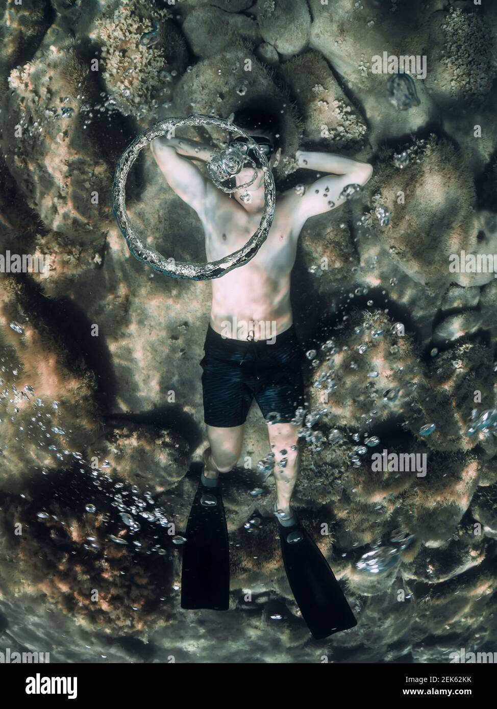 Tuffatore libero che fa le bolle dell'anello in mare. Uomo sportivo freediver in estate mare Foto Stock