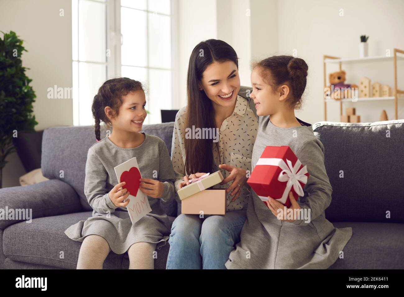 La madre felice riceve i regali e la cartolina fatta a mano dalle sue due figlie amorevoli. Foto Stock