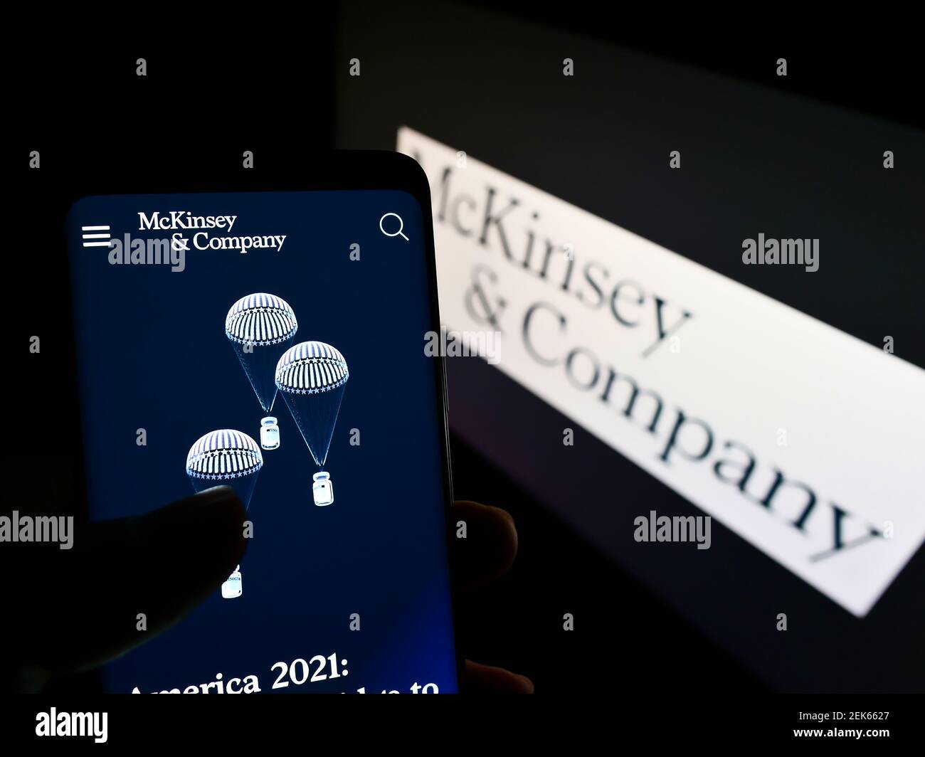 Persona che tiene il telefono mobile con il sito web della società di consulenza di gestione McKinsey Company sullo schermo davanti al logo. Mettere a fuoco il centro del display del telefono. Foto Stock