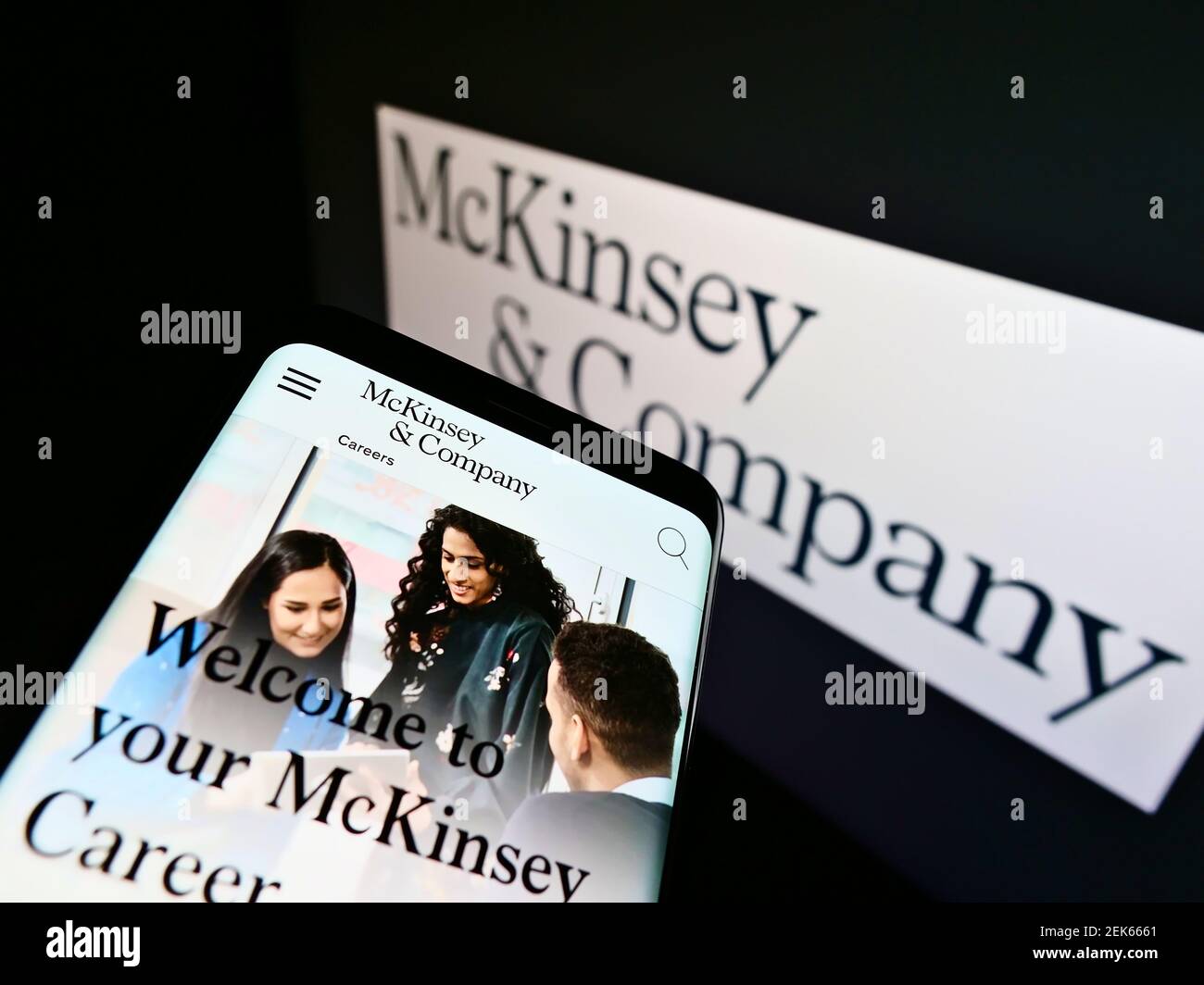 Smartphone con sito web professionale di consulenza aziendale McKinsey Company sullo schermo davanti al logo. Mettere a fuoco in alto a sinistra del display del cellulare. Foto Stock