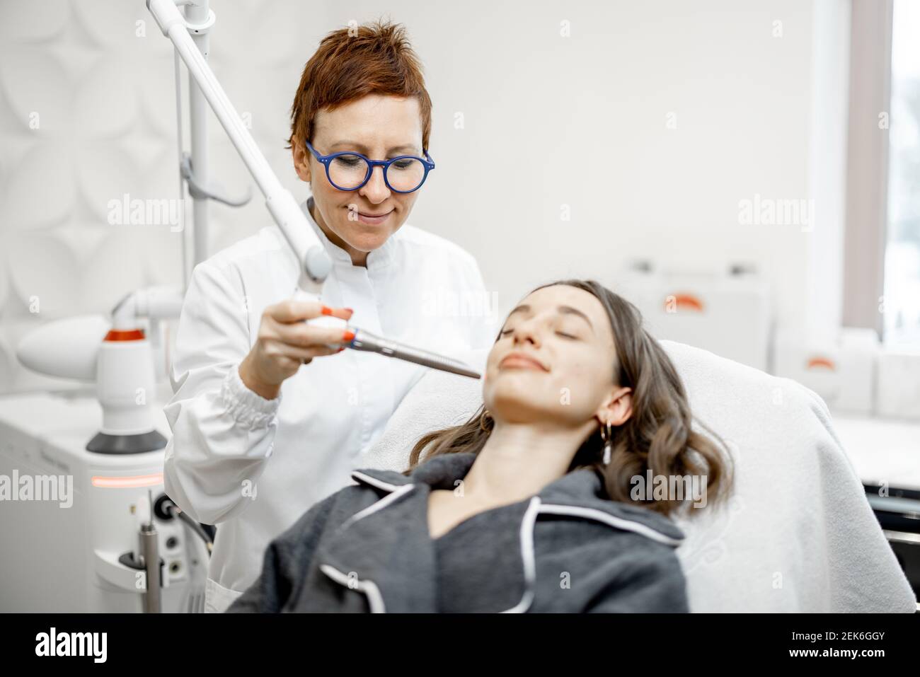 Cosmetologist che fa la procedura di facelifting del laser in clinica di bellezza Foto Stock