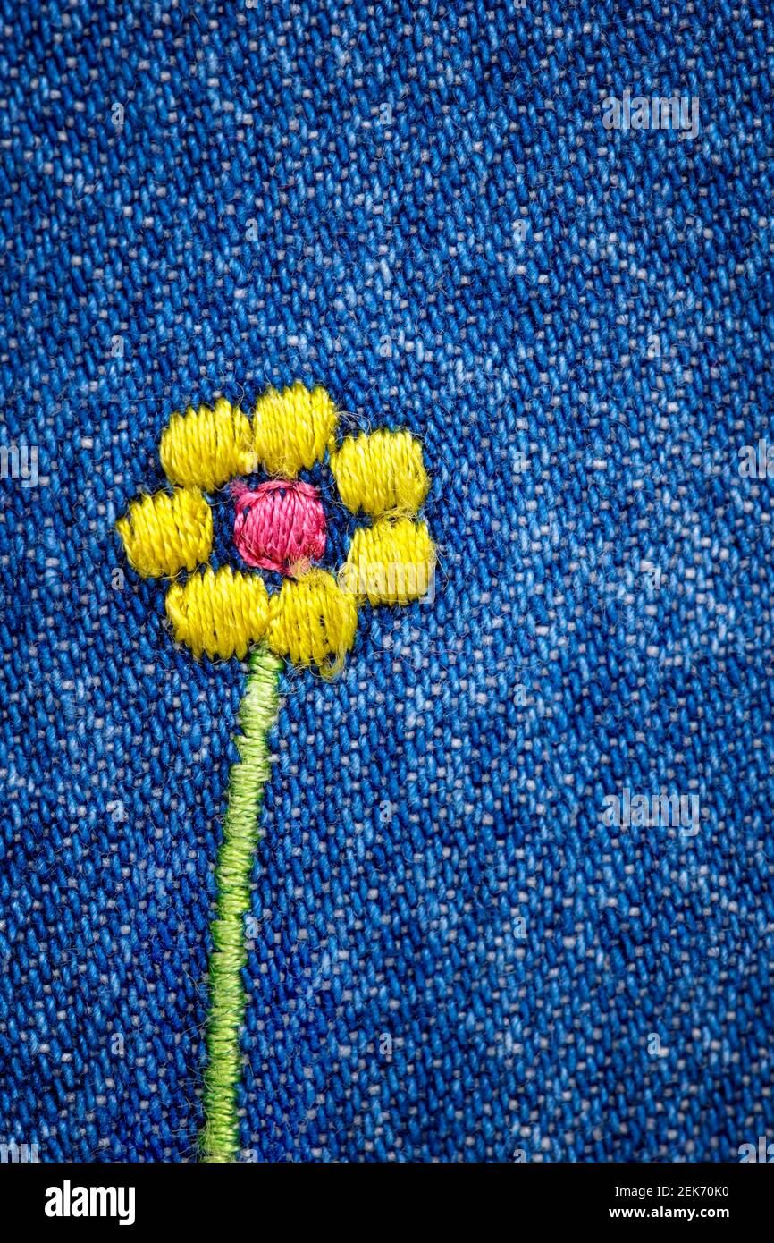 Fiore ricamato su frammento di tessuto jeans denim blu Foto Stock