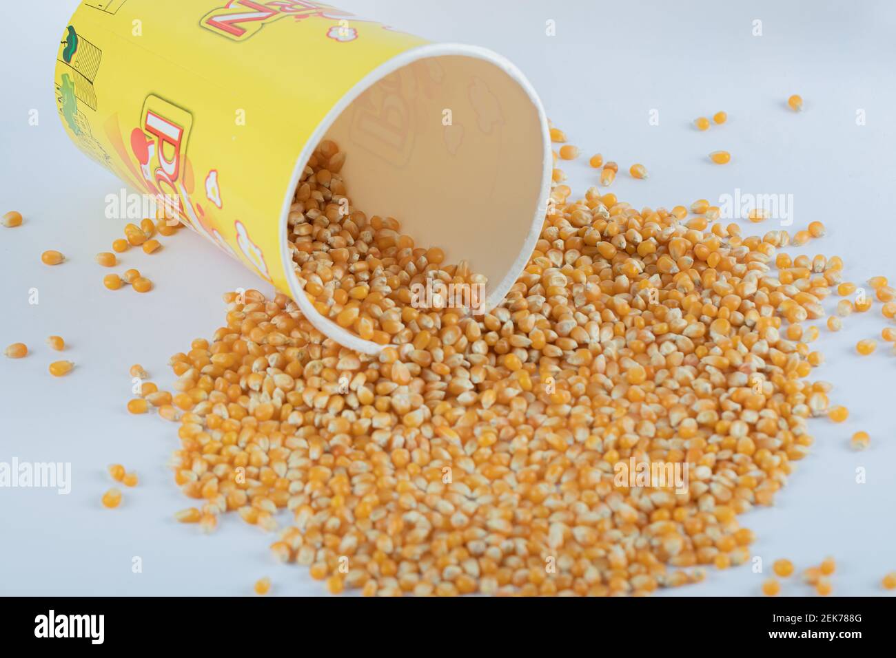 Un secchio di cartone giallo con popcorn crudo Foto Stock