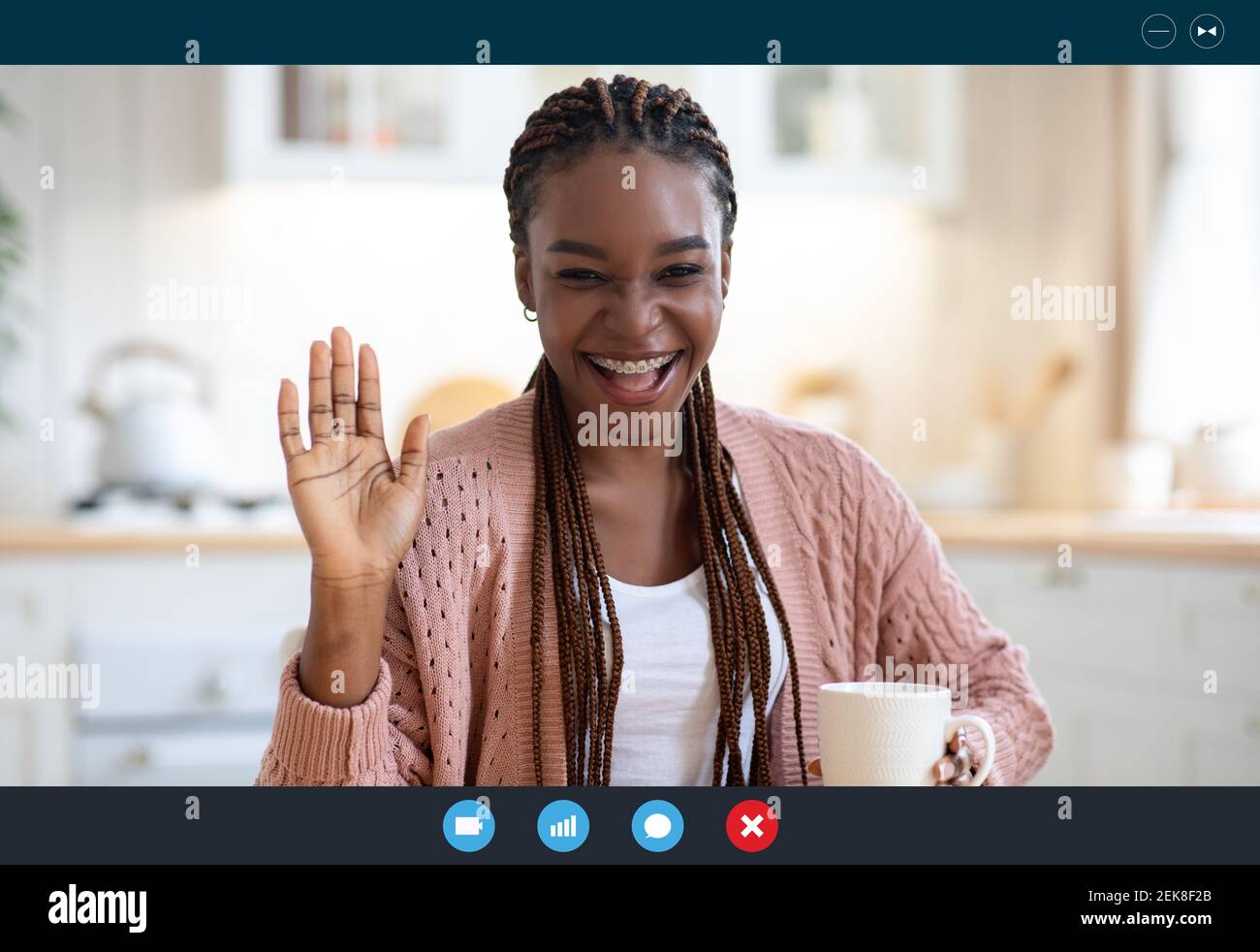 Allegra donna nera che ha Video Conferenza mentre beve caffè in cucina, Screenshot Foto Stock