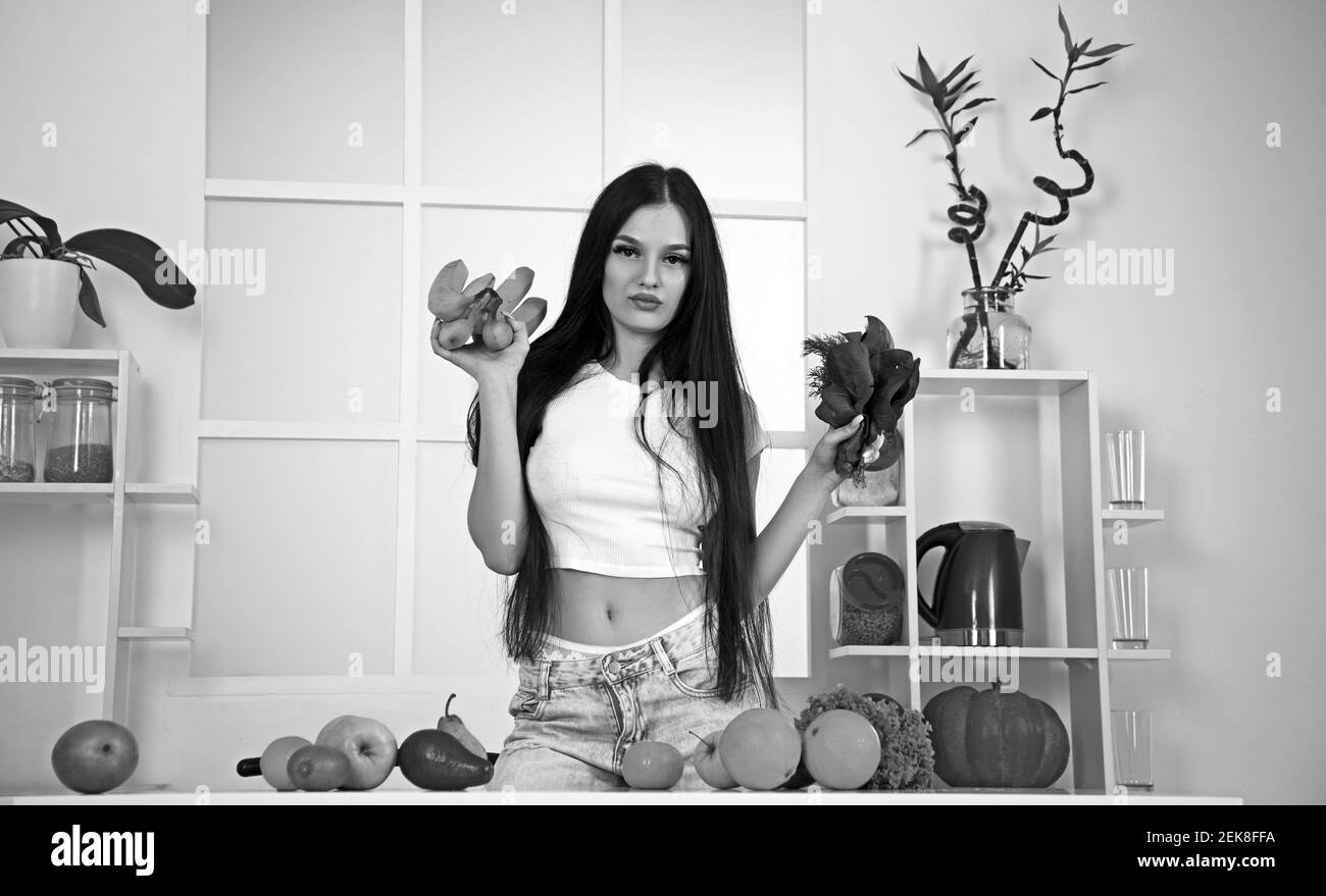 Bella ragazza brunette è in piedi con frutta fresca in cucina Foto Stock