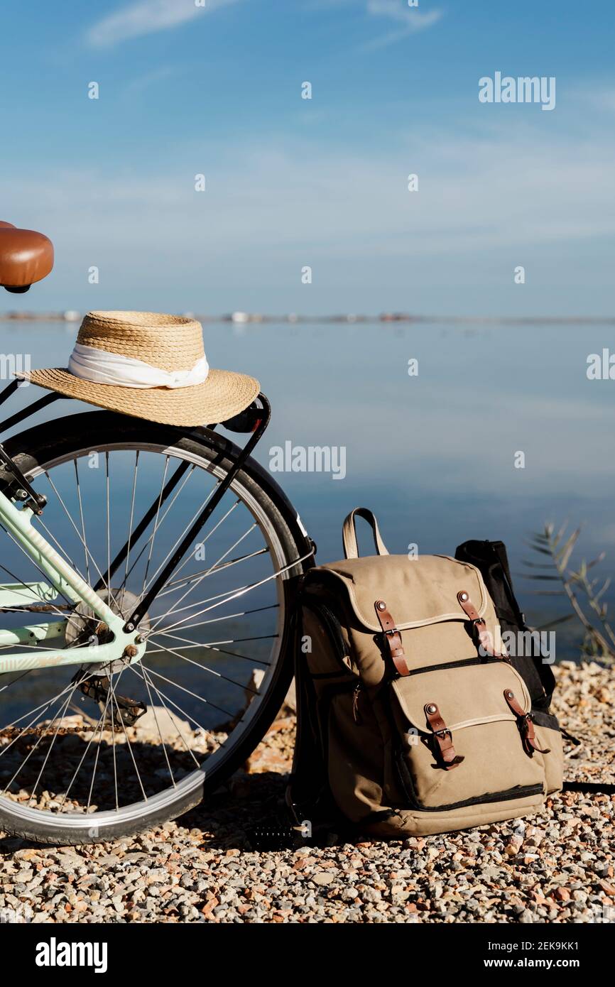 Cappello da sole tenuto in bicicletta dallo zaino contro il cielo nella giornata di sole a Ebro Delta, Spagna Foto Stock