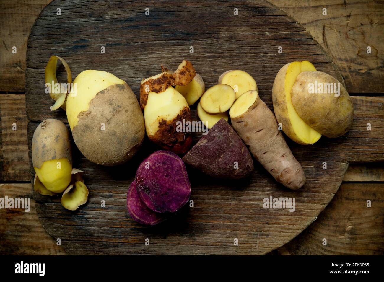 Diversi tipi di patate: Glorietta, patata dolce viola, Agria, Annabelle, Bamberger Hoerndl, Gala su sfondo rustico in legno Foto Stock