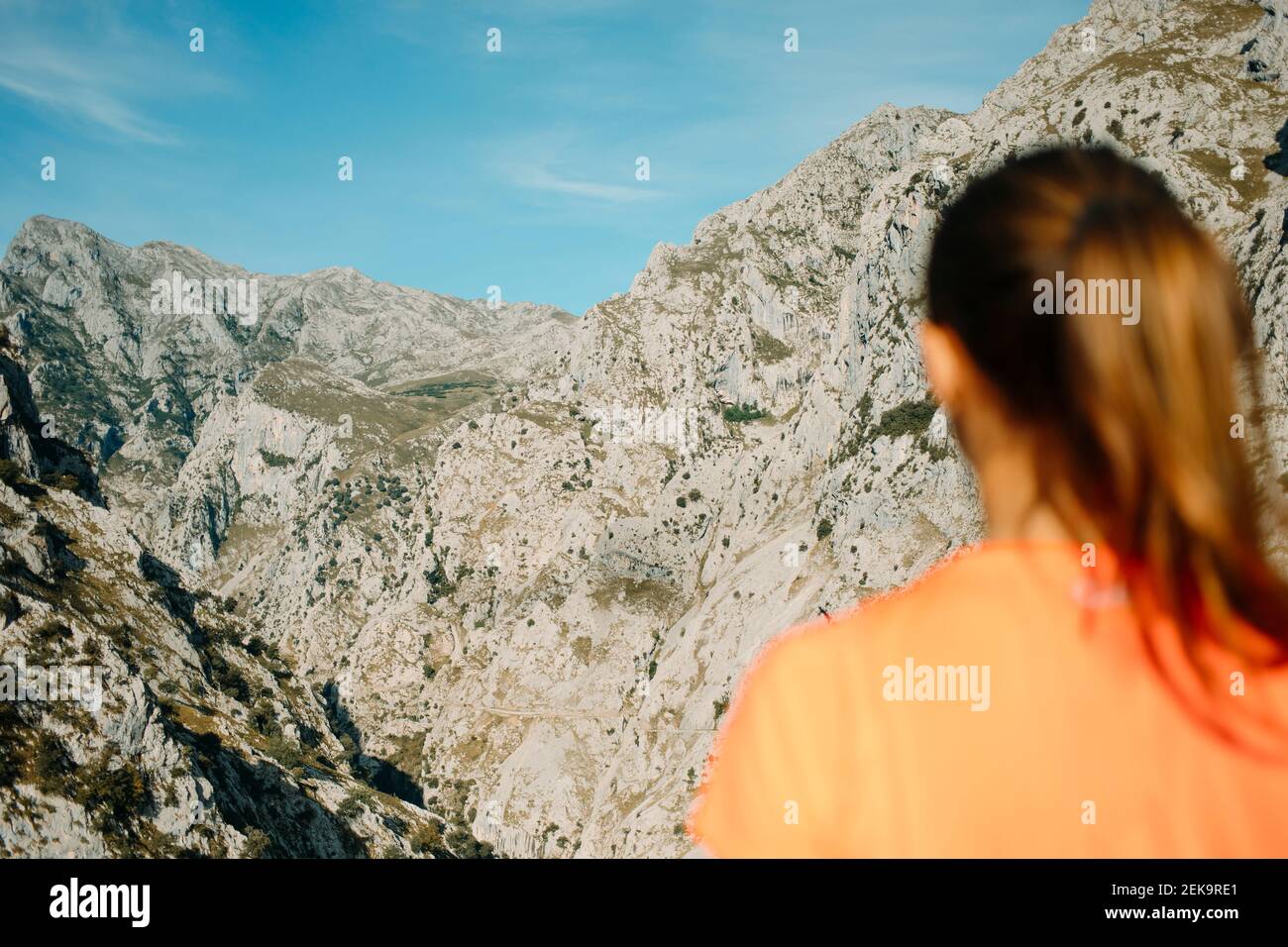 Donna escursionista ammirando la vista sulle montagne mentre si trova a Cares Trail nel Parco Nazionale Picos De Europe, Asturias, Spagna Foto Stock