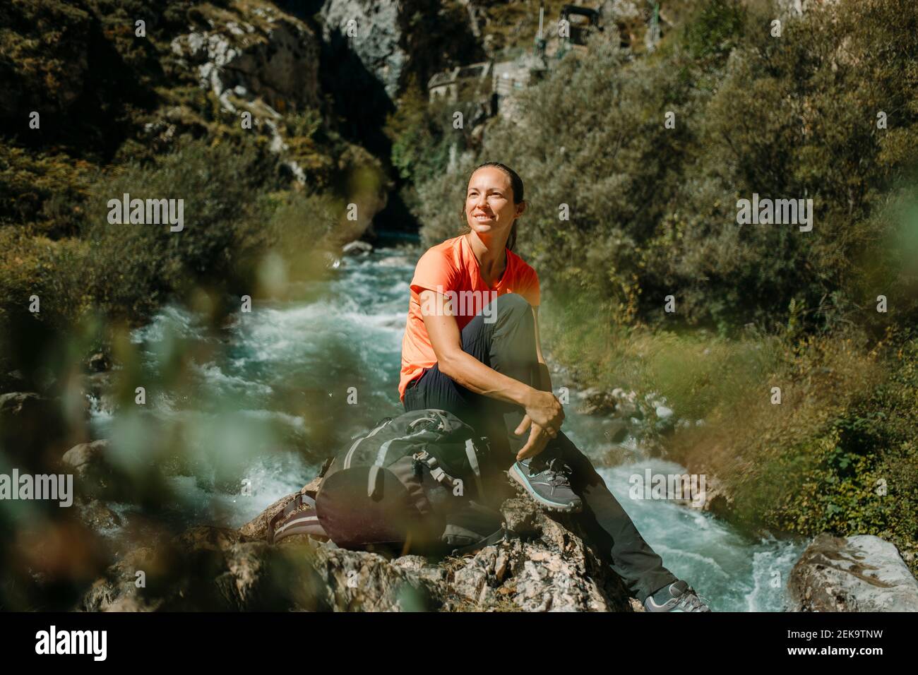 Donna escursionista con zaino riposato mentre si siede al Cares Trail nel Parco Nazionale Picos De Europe, Asturias, Spagna Foto Stock