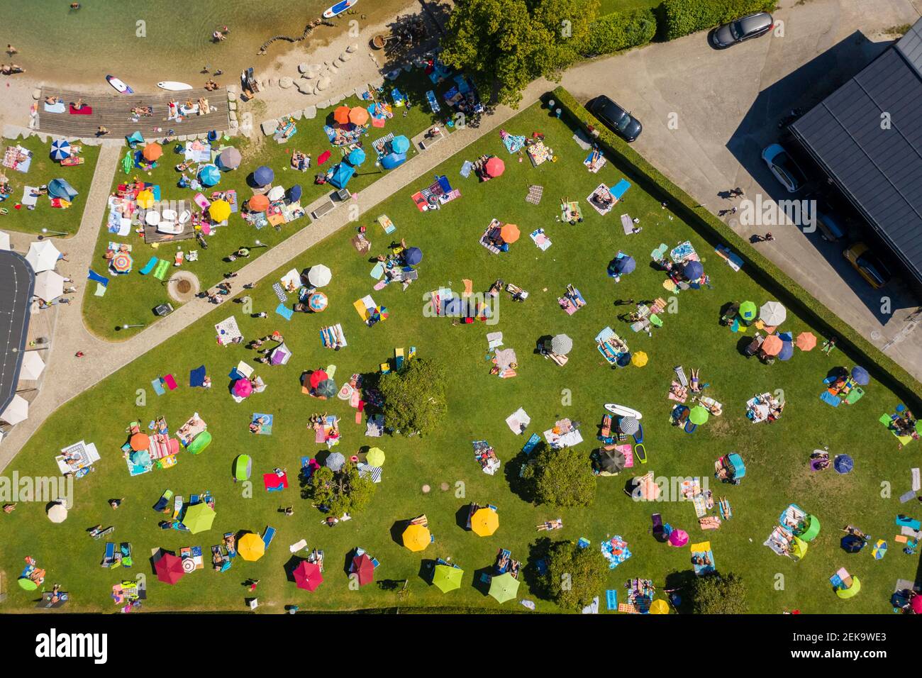 Austria, Salisburgo, Sankt Gilgen, veduta aerea di un grande gruppo di persone che prendono il sole sul prato verde in estate Foto Stock