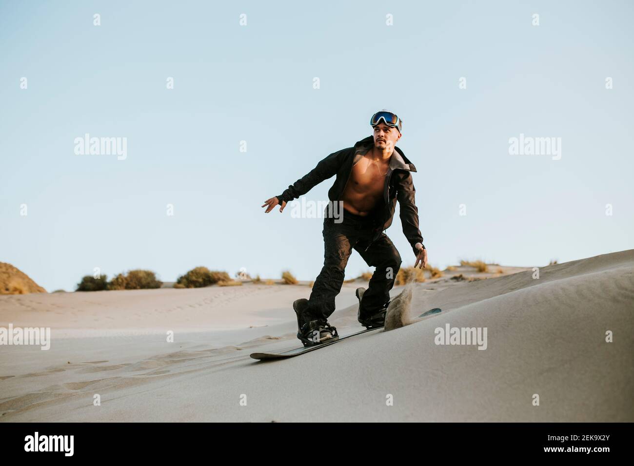 Sandboarding giovane uomo nel deserto ad Almeria, Tabernas, Spagna Foto Stock