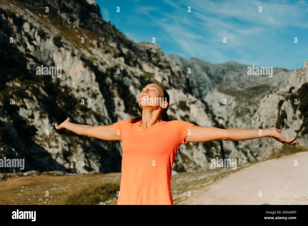 Donna sorridente in piedi con le braccia distese a Cares Trail nel Parco Nazionale Picos De Europe, Asturias, Spagna Foto Stock