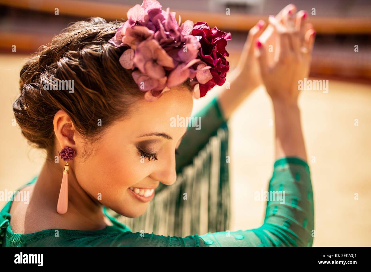 Primo piano di ballerina di flamenco con fiori che le aggrappano le mani Foto Stock