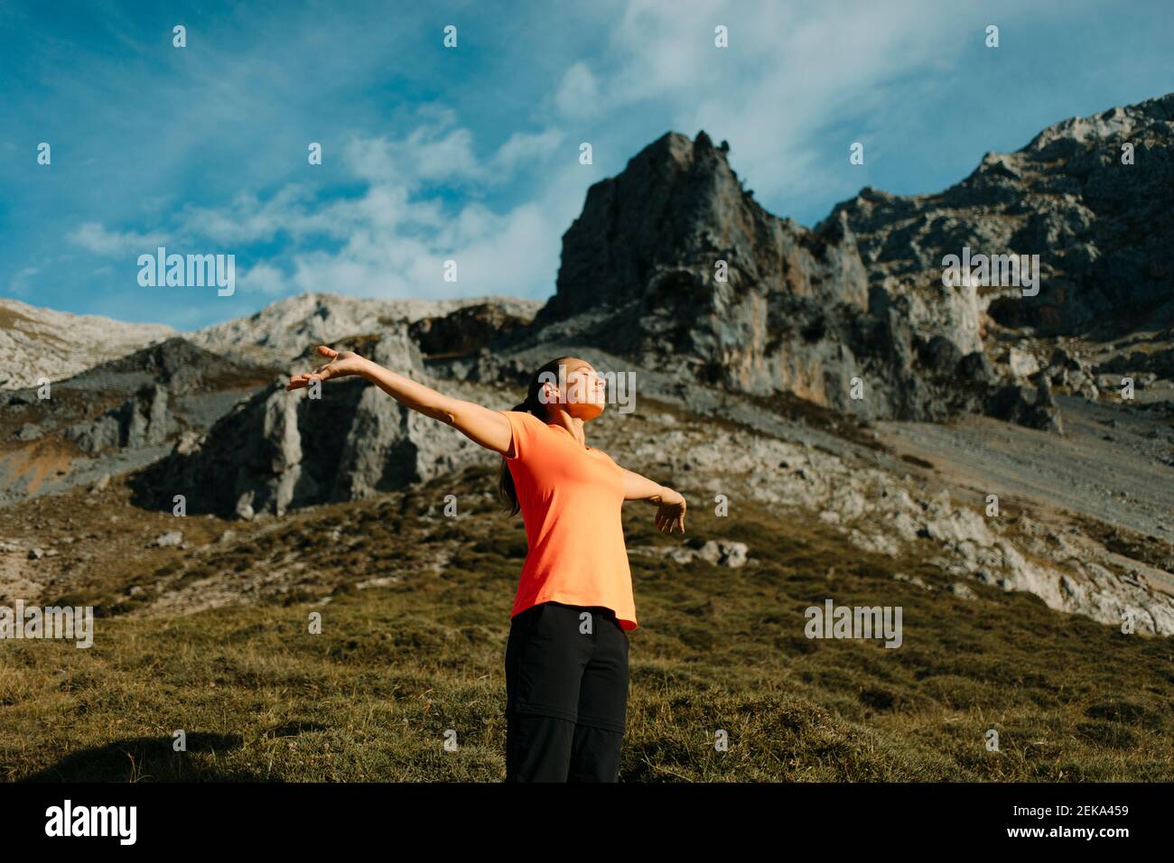 Escursionista in piedi con le armi stese contro la montagna a Cares Trail nel Parco Nazionale Picos De Europe, Asturias, Spagna Foto Stock