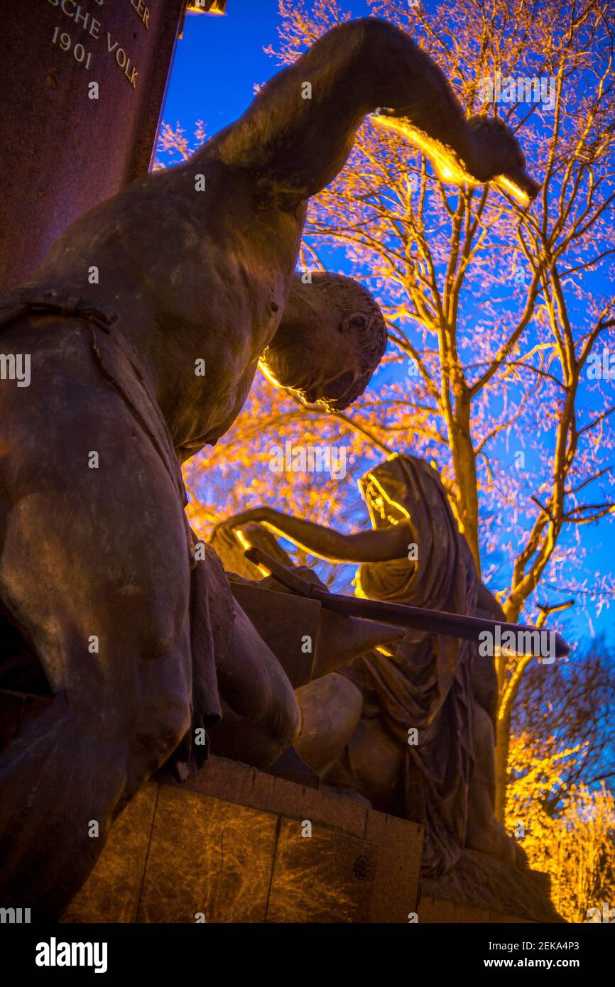 Germania, Berlino, Bismarck statua commemorativa di Sigurd forgiare la spada con sibil sullo sfondo Foto Stock