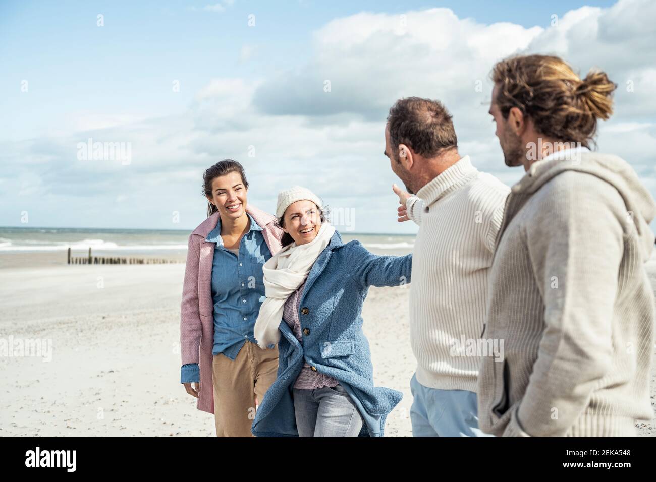 Gruppo di amici adulti sulla spiaggia costiera Foto Stock