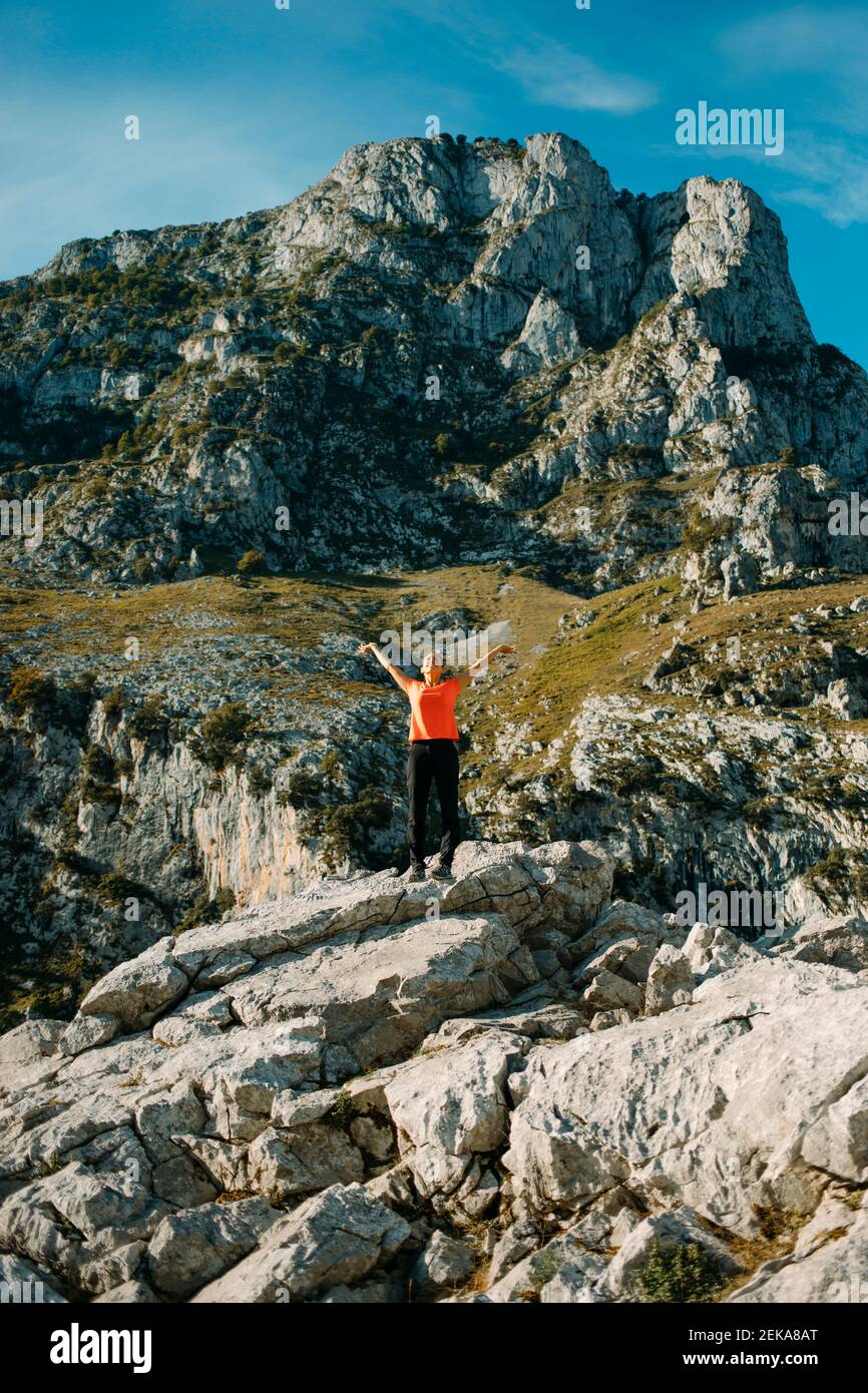 Donna spensierata con le braccia stese in piedi in montagna a Cares Trail nel Parco Nazionale Picos De Europe, Asturias, Spagna Foto Stock