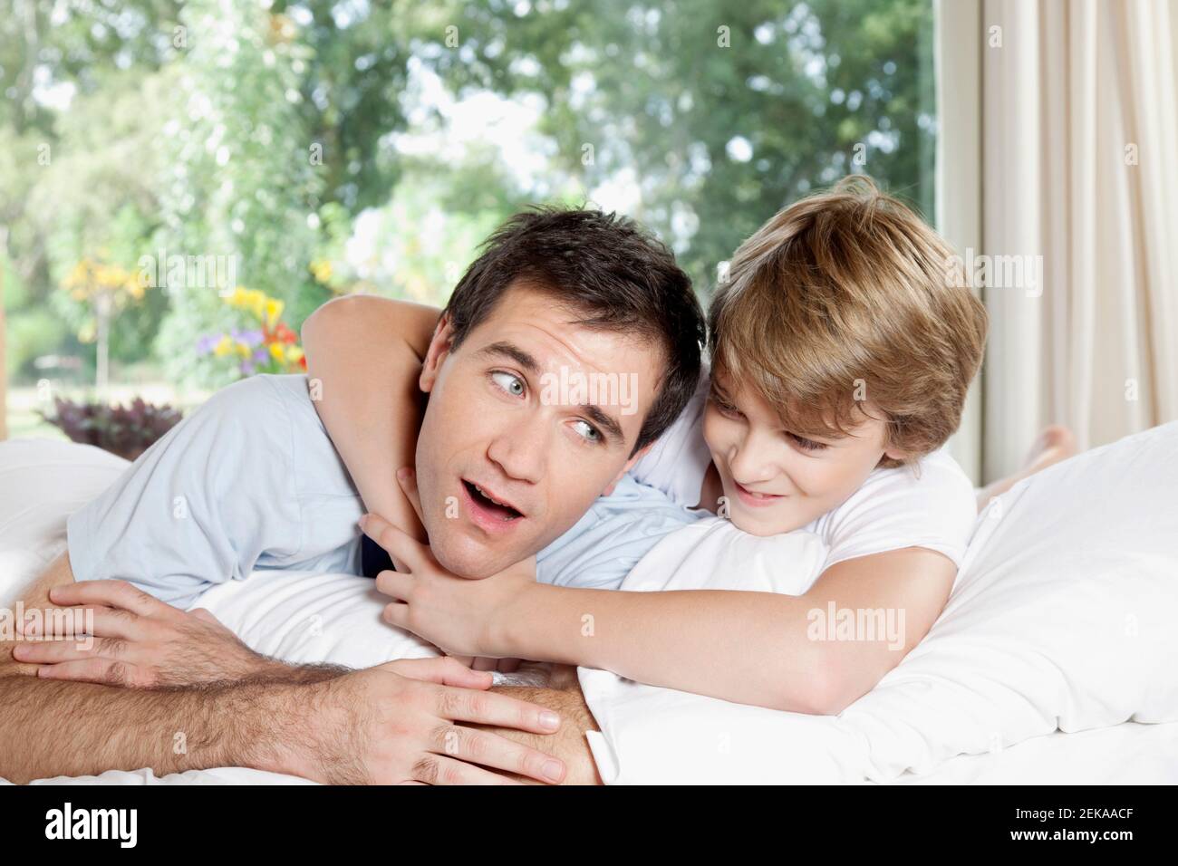 Ragazzo che tiene il padre in headlock Foto Stock