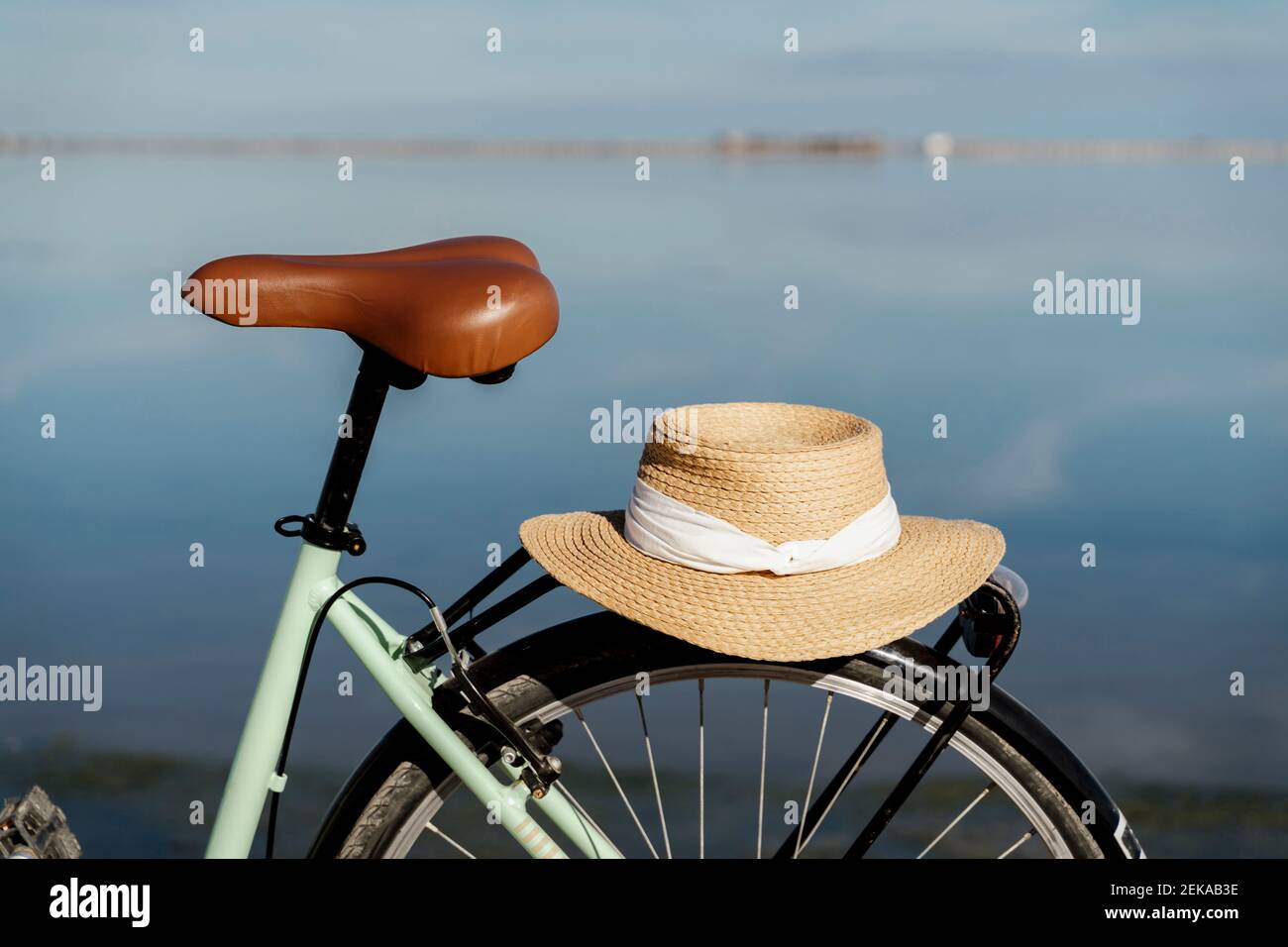 Cappello beige tenuto in bicicletta parcheggiato durante la giornata di sole al Delta di Ebro, Spagna Foto Stock