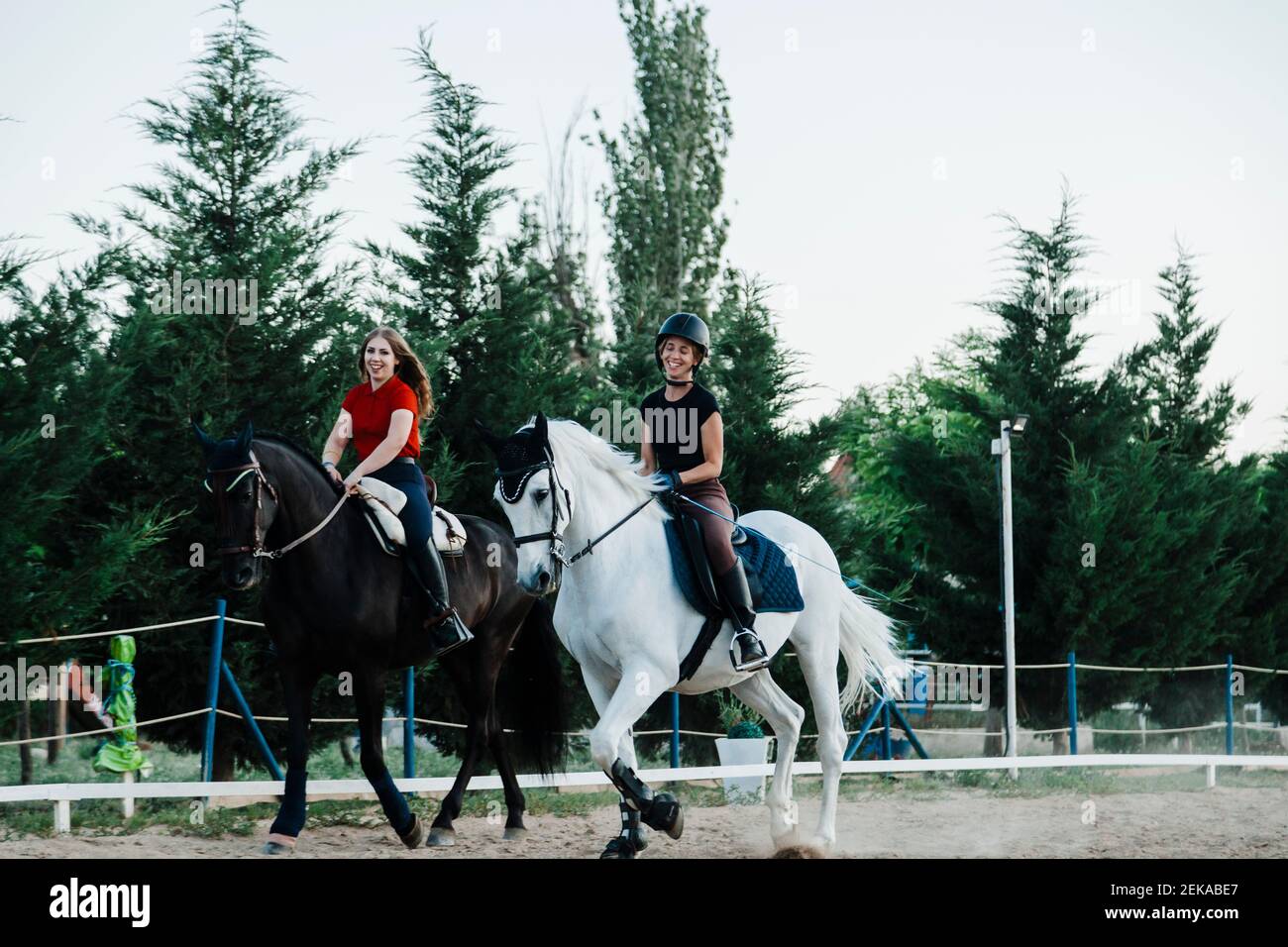 Felici le amiche a cavallo in fattoria Foto Stock