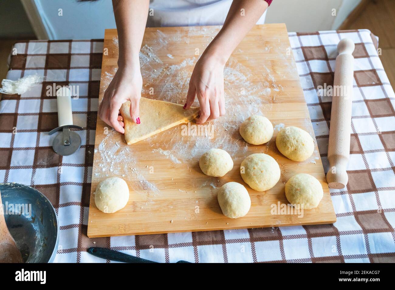 Donna che fa palle di impasto sul tagliere per preparare croissant in  cucina Foto stock - Alamy