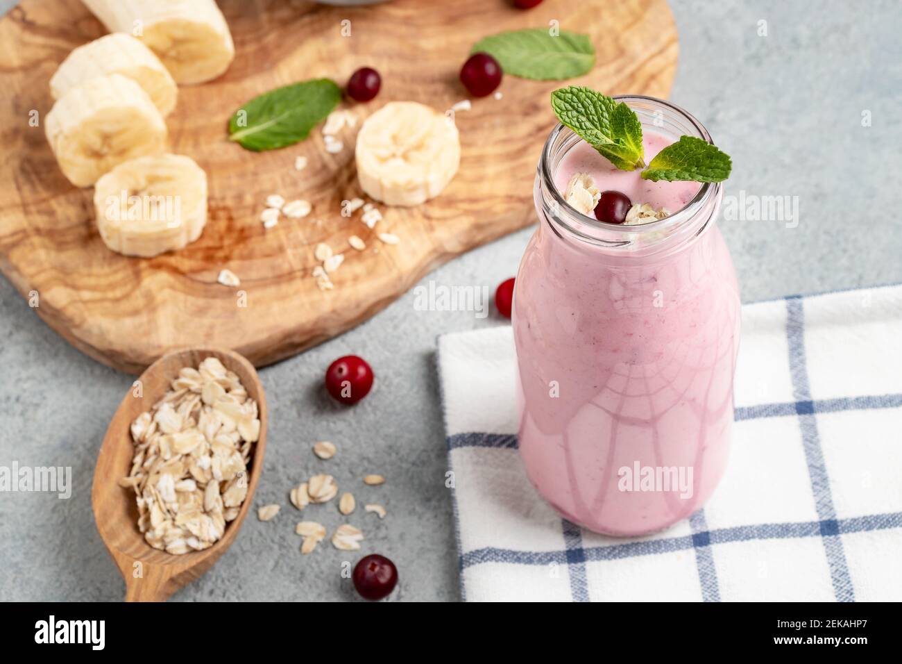 Frullato di yogurt fatto in casa con banana, mirtillo rosso e farinata d'avena. Foto Stock