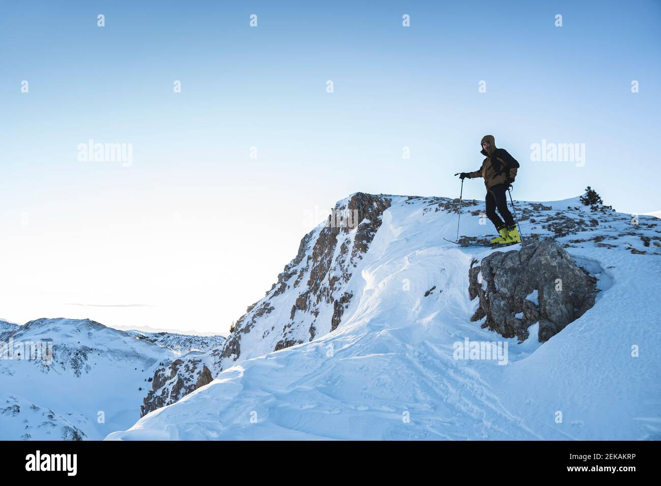 Scalatore di montagna maschile sulla cima di montagna contro il cielo Foto Stock