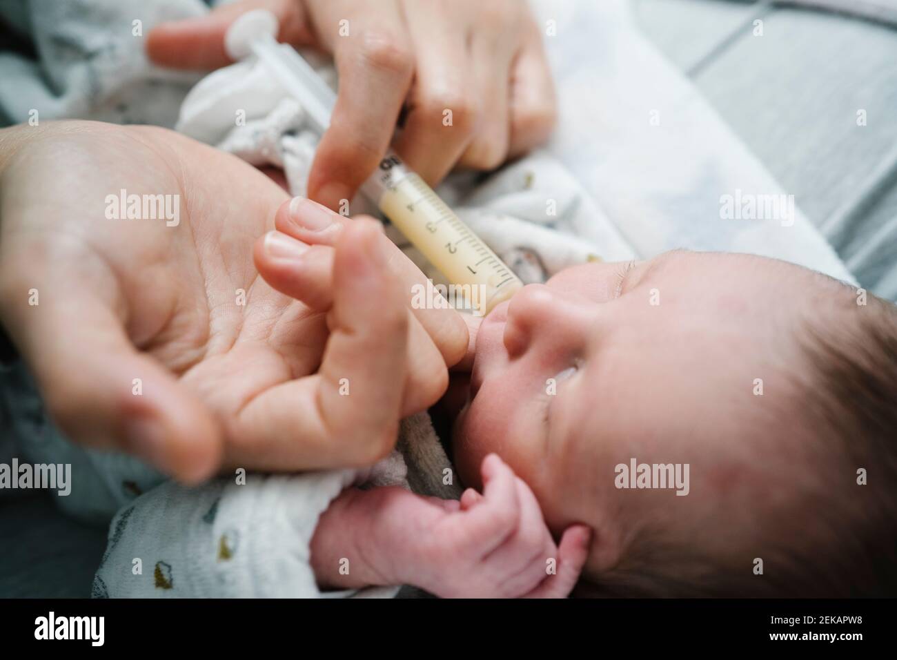 Donna che allatta bambino neonato con iniezione in ospedale Foto Stock