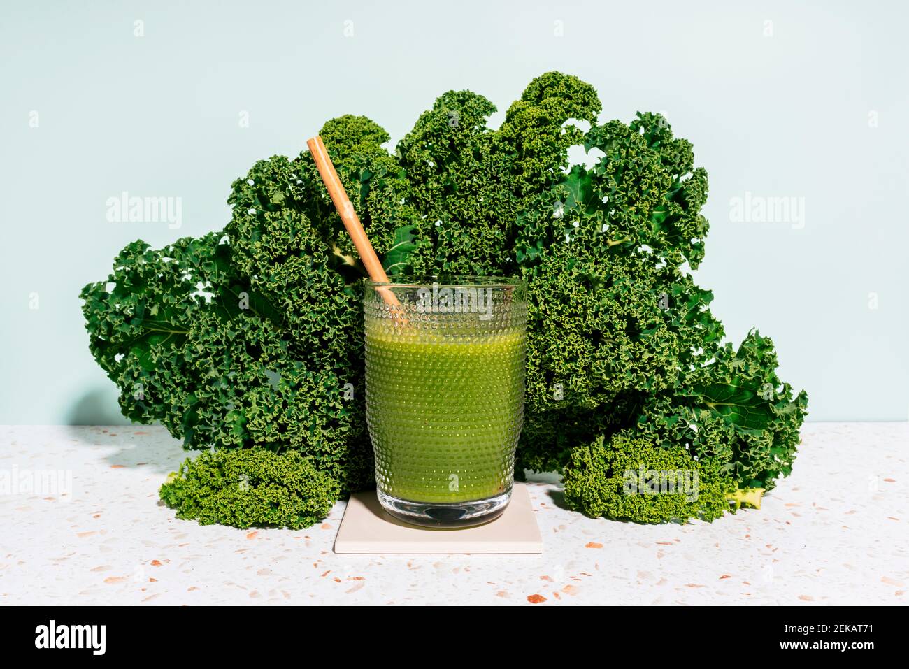 Succo verde estivo sano con kale contro il muro a casa Foto Stock