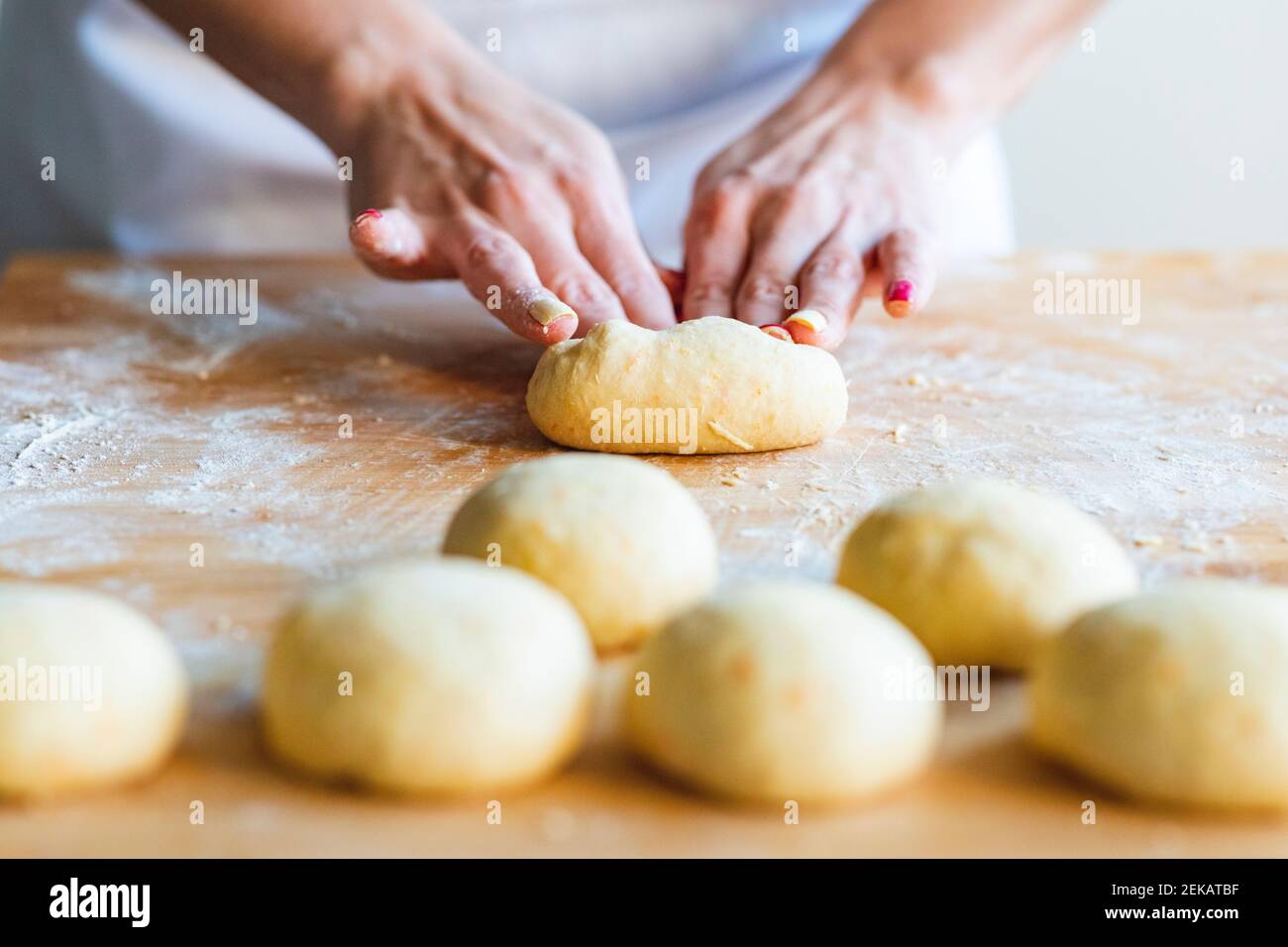 Donna che impastava le palle per preparare croissant in cucina Foto Stock