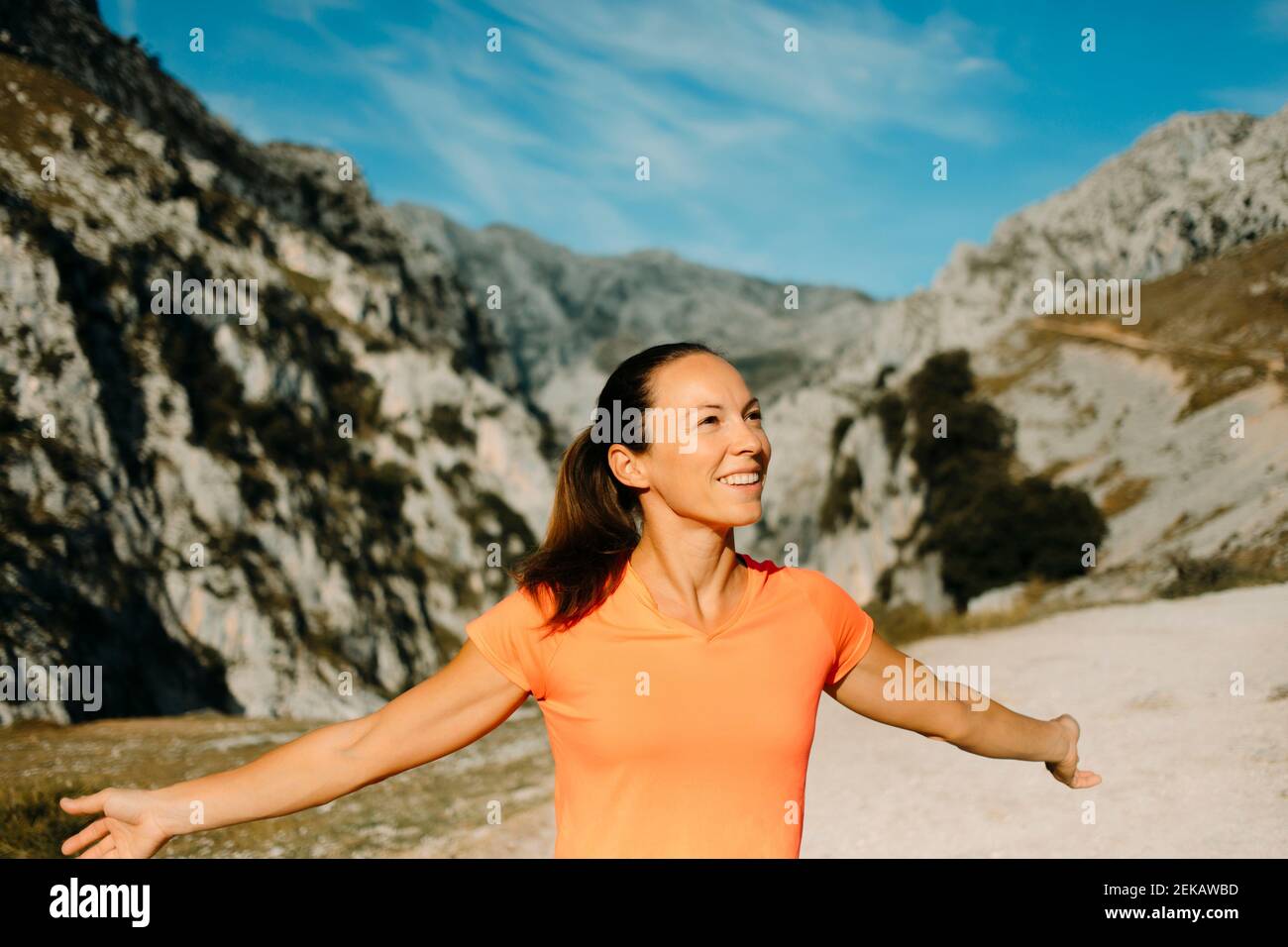 Escursionista spensierato sorridendo mentre si alza in piedi con le braccia al Cares Trail nel Parco Nazionale Picos De Europe, Asturias, Spagna Foto Stock
