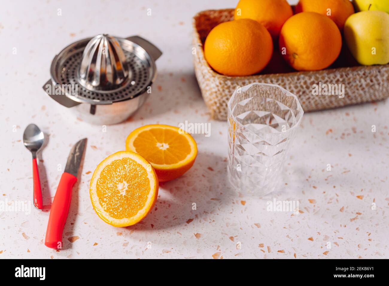 Bicchiere vuoto con centrifuga in acciaio inossidabile e arancione tenuto in marmo moderno Foto Stock