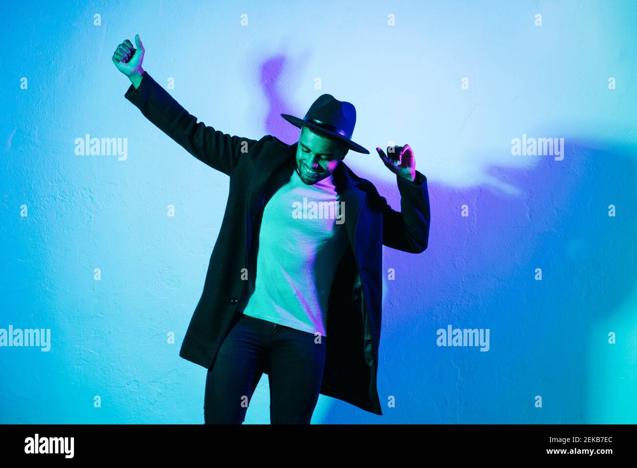 Uomo in abbigliamento casual danzante su sfondo colorato Foto Stock