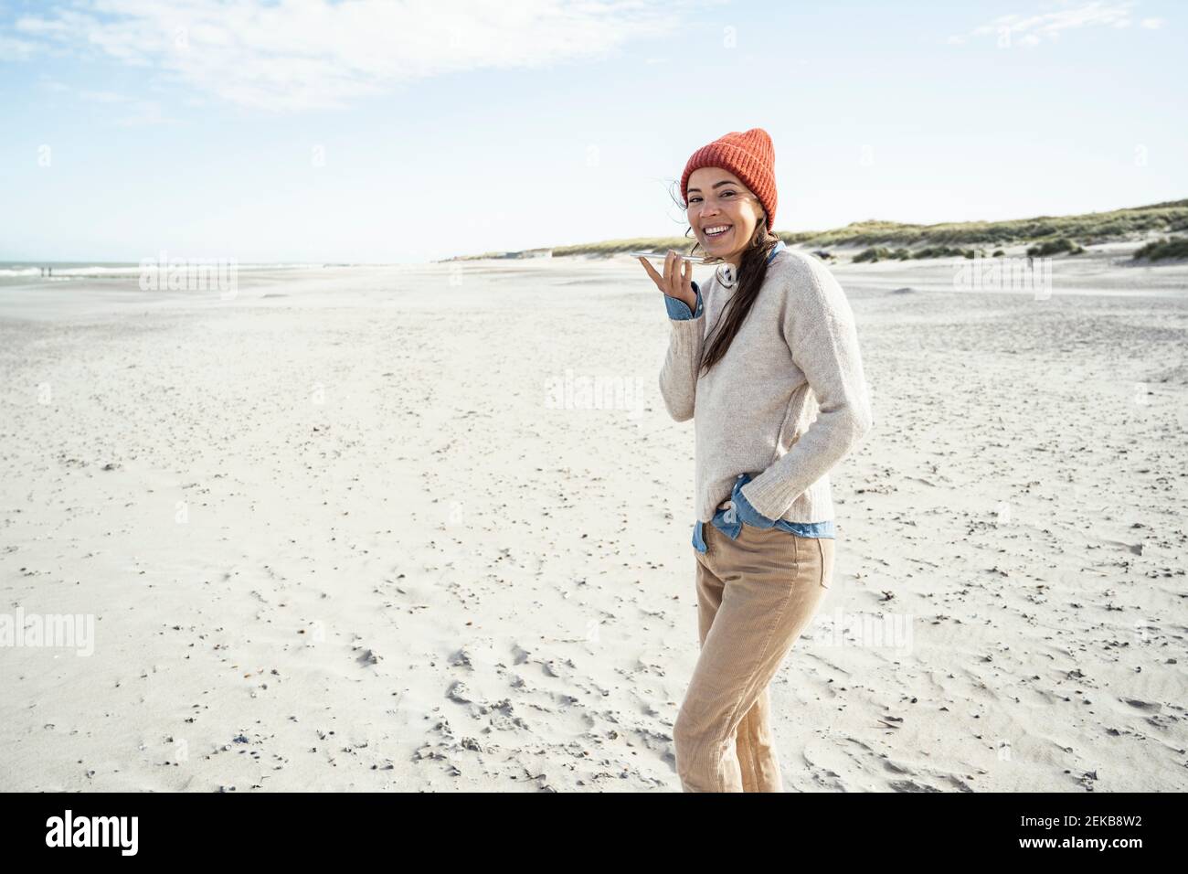 Ritratto di donna in piedi da sola sulla spiaggia di sabbia Foto Stock