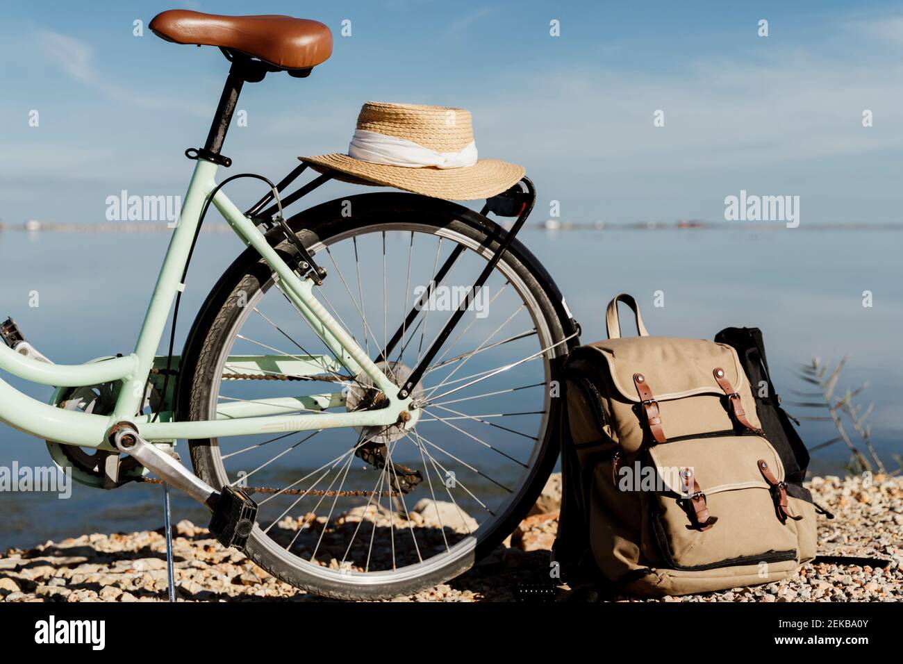 Zaino appoggiato in bicicletta con cappello a Ebro Delta contro il cielo in giornata di sole, Spagna Foto Stock