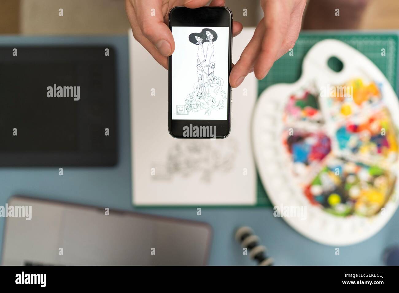 Artista che scatta foto di design tramite il telefono cellulare a casa Foto Stock