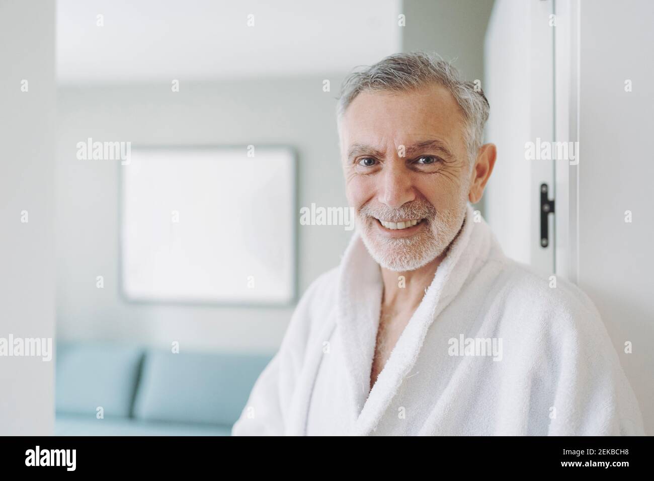 Uomo felice in accappatoio in camera d'albergo Foto Stock
