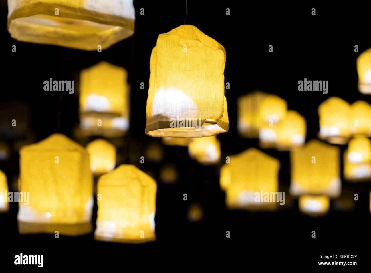 Lampade di design illuminate appese all'aperto di notte Foto Stock
