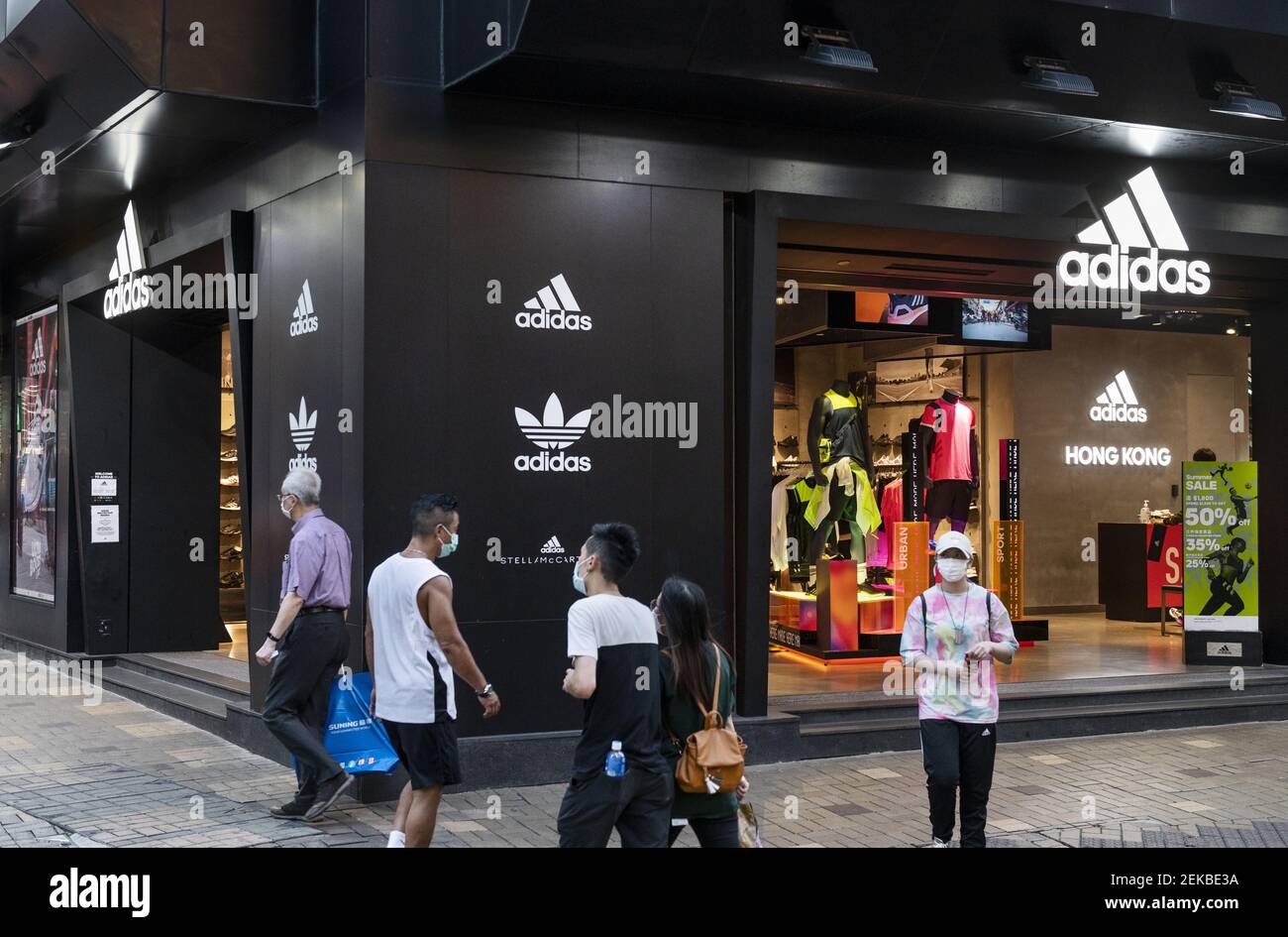 I pedoni passano davanti a un negozio di abbigliamento sportivo tedesco di  marca Adidas visto a Hong Kong. (Foto di Budrul Chukrut / SOPA Images/Sipa  USA Foto stock - Alamy